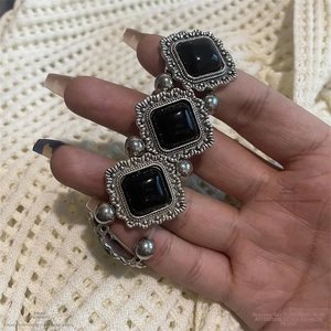 Vue détaillée du bracelet rétro argenté avec grandes pierres en résine noire