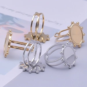 Detail view of adjustable gold and silver ring bases with gear-shaped settings for DIY crafts