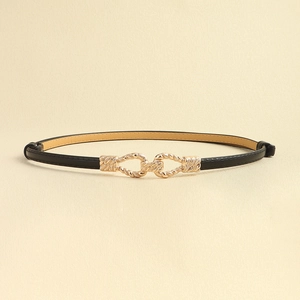 Minimalist black thin leather belt with golden twist buckle for dresses on beige backdrop