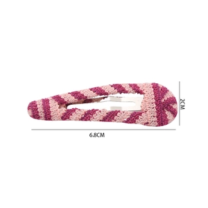 Détail macro d'une barrette à cheveux au crochet rayée rose faite main de 6,8 cm