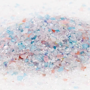 Macro shot of 2-8mm colorful crushed glass stones and white pearls for DIY nail art