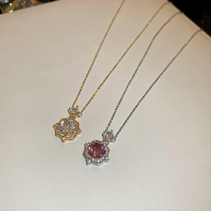 Detail showing 14k gold plated and silver necklaces with zircon pendants on leather surface