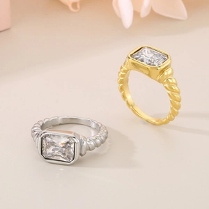Macro detail of gold and silver twisted band rings with rectangular clear zircon stones