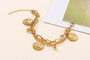 Detail of gold double-layer titanium steel bracelet featuring sun pendant and toggle clasp