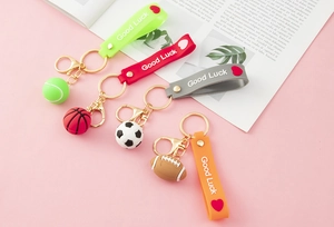 Detail of colorful sports keychains with 3D soccer, basketball, tennis, and rugby pendants