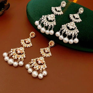 Detailed shot of fan-shaped tassel pearl earrings with crystals on a jewelry box