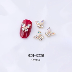 Détail d'un bijou d'ongle papillon 3D 9x9mm avec cristaux marquise sur un ongle rouge