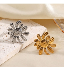 Détail de bagues tournesol argent et or sur pierre blanche et fond en soie beige