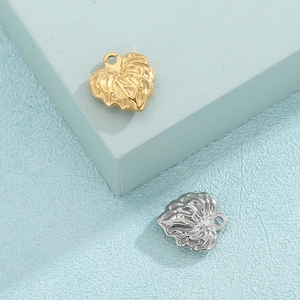 Pendentifs feuilles en or et argent avec texture gaufrée sur socle géométrique bleu