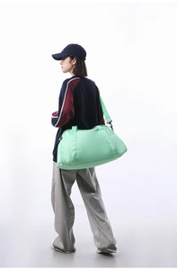 Mint green large capacity travel duffel bag carried by model for gym or short trips