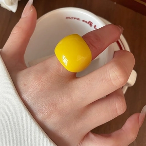 Fashionable oversized yellow resin geometric ring with smooth glossy finish on hand