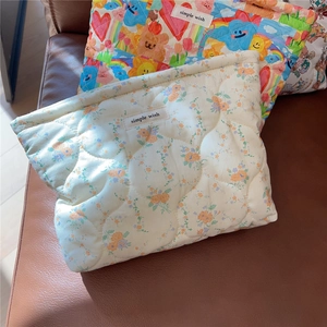 Detail of quilted makeup bags with floral and cartoon prints featuring simple wish label