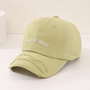 Detailed view of frayed edges on a light green cotton baseball cap with Paris Best embroidery