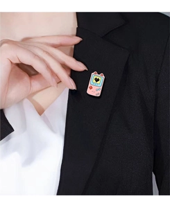 Close-up of pink retro game console enamel pin with cat ears on a black blazer collar