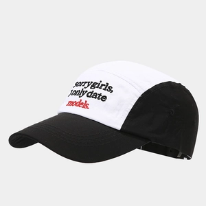 Detail of 5-panel camper cap featuring sorry girls embroidery and contrasting black and white panels