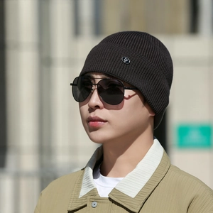Dark brown ribbed knit beanie with metal logo detail and warm lining for winter wear