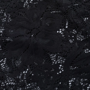 Detailed macro view of black floral lace fabric with intricate mesh cutout embroidery