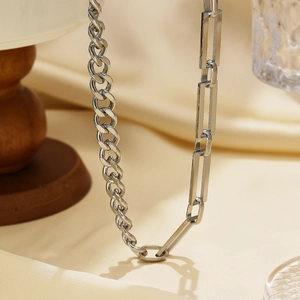 Collana a catena cubana argentata e catena a graffetta su tessuto beige liscio
