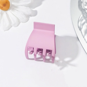 Close-up of a small purple plastic shark hair claw clip for high ponytail styling