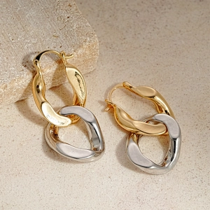 Two-tone gold and silver geometric oval chain earrings on minimalist stone decor