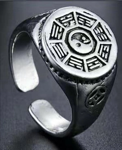 Macro shot of punk dragon claw ring featuring Tai Chi Yin Yang symbol and ancient coin carving