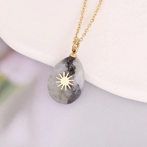 Detailed shot of drop-shaped natural stone pendant on a gold stainless steel chain