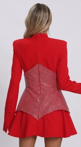 Detail of red long sleeve dress showing sparkling rhinestones and structured back silhouette