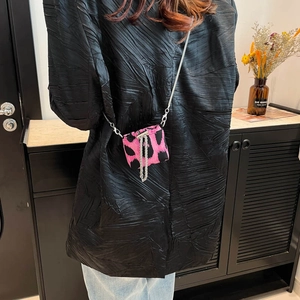 Pink and black leopard print mini crossbody bag with silver chain strap on model