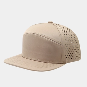 Detail view of khaki laser-cut breathable vents on a flat brim baseball cap