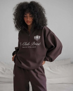 Détail du logo Club Privé et du col zippé sur ce sweat décontracté marron foncé