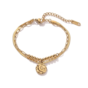 Detail view of double-layer gold stainless steel bracelet with moon star pendant