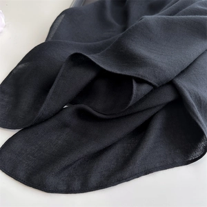 Detail of soft black linen blend fabric texture with elegant drapes and folds