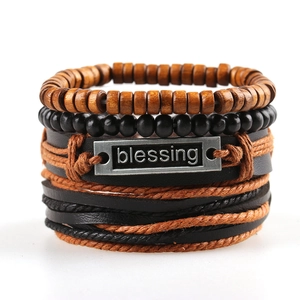 Detail of layered braided bracelet with wooden beads and silver blessing metal plate