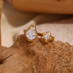 Detail of 18K gold plated open ring with teardrop and star zircon on wood