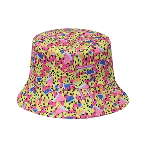 Détail du chapeau de soleil jaune avec motifs géométriques et imprimé style Memphis