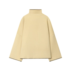 Minimalist oversized high-neck sweater in cream yellow with dark contrast whipstitch edges