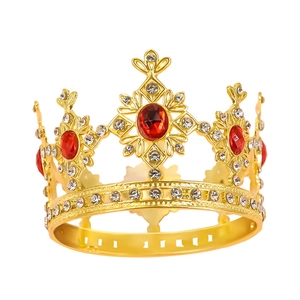 Golden crown cake topper with sparkling red oval gemstones and clear crystals on white background