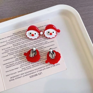 Vue détaillée du clip d'oreille Père Noël sur carte vintage pour oreilles non percées
