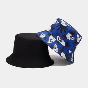 Detail view of double-sided bucket hats in plain black and blue skull floral print