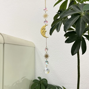 Detail of golden moon and suncatcher with faceted crystal prisms for garden decoration
