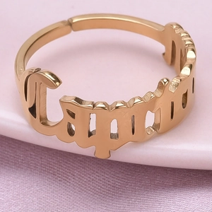 Detailed macro view of gold Capricorn gothic letter engraving on an adjustable open ring