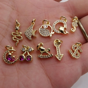 Set of 10 gold plated DIY pendants with micro-pave zircons in palm of hand