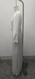 Detail of elegant V-neck dress featuring white satin top and silver sequined long skirt