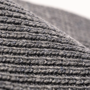Close-up of charcoal gray chunky knit beanie showing soft wave texture and warm wool fabric