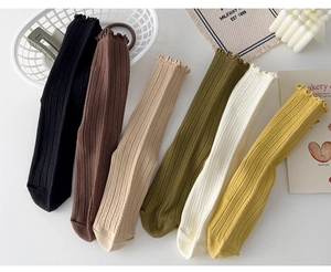 Flat lay of six pairs of ruffled cotton socks in autumn colors with lifestyle props