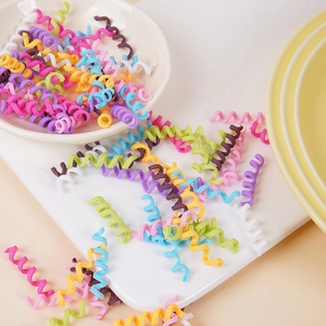 Colorful spiral hair ties in vibrant macaron shades on a white ceramic tray