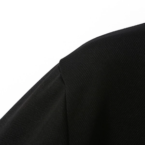 Close-up of the shoulder stitching and textured fabric on this black long-sleeve polo shirt