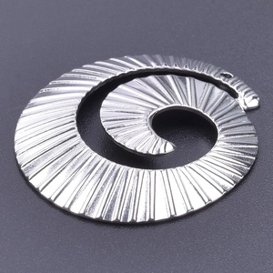 Macro shot of silver spiral stainless steel pendant with radial texture for DIY jewelry