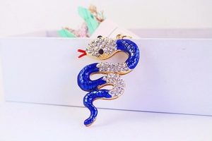 Macro shot of blue enamel snake keychain with sparkling rhinestones and gold plating