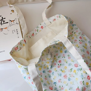 Detailed interior of floral canvas tote bag featuring an inner pocket and wide strap